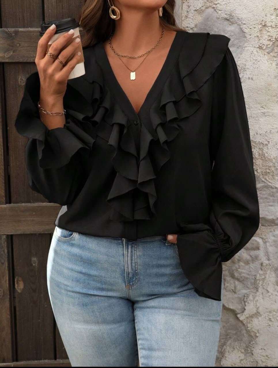 Blusa negra con volantes en el escote y jeans